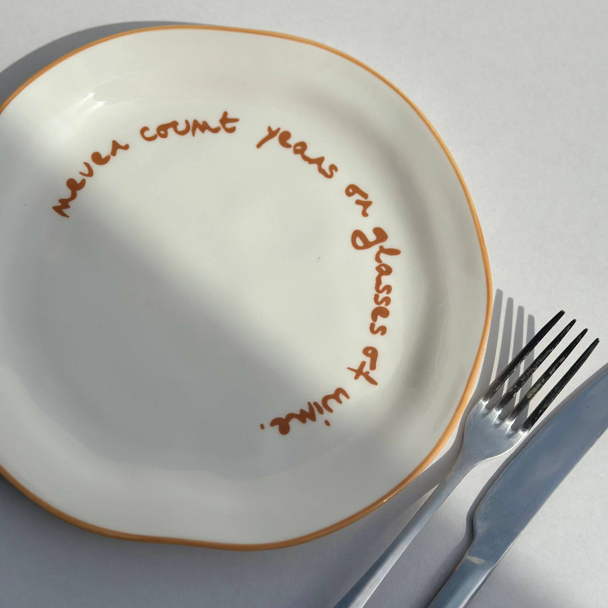 'never count years of glasses of wine.' Statement Plate