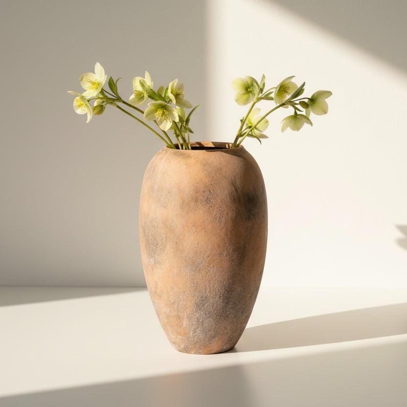 Terracotta vase with a textured surface on a white background