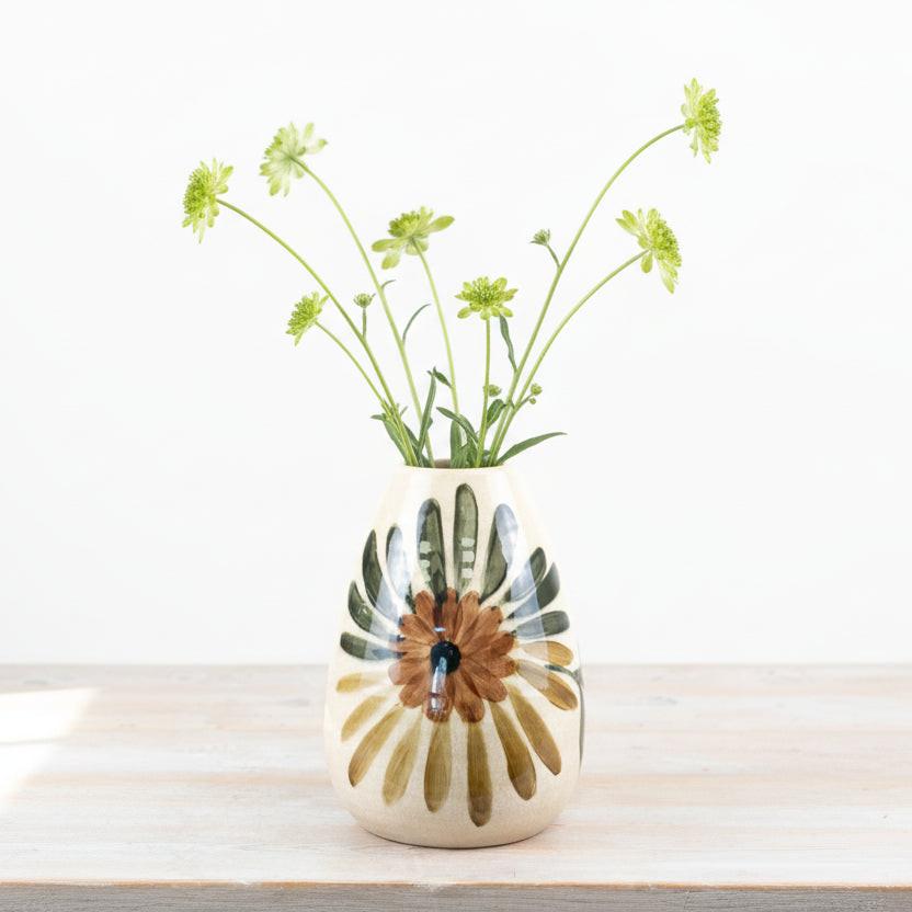 Ceramic vase with floral design on a wooden surface