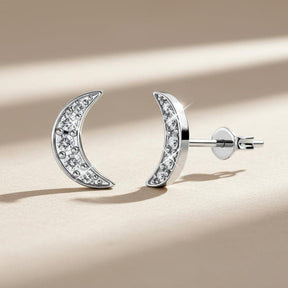 Silver moon-shaped earrings with embedded stones on a white background