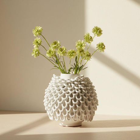 White ceramic vase with a unique, textured design on a white background