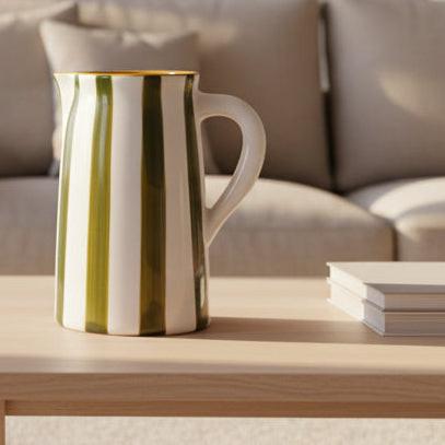 Ceramic pitcher with green and white stripes on a white background
