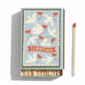 Matchbox with decorative design of doves and flowers, accompanied by a single matchstick.