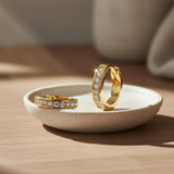 Gold hoop earrings with clear gemstones on a white background