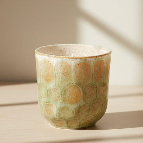 Ceramic candle holder with a textured surface on a white background