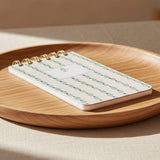 Notebook with a decorative cover featuring blue and green patterns on a white background