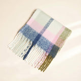 Plaid scarf with fringe on a beige background