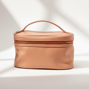 Tan cosmetic bag with a handle on a white background