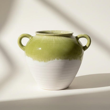 Green and white ceramic vase with handles on a white background