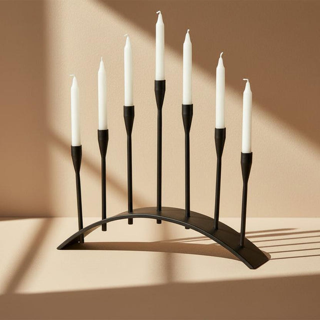 Black metal candelabra with multiple candle holders on a white background