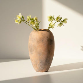 Terracotta vase with a textured surface on a white background