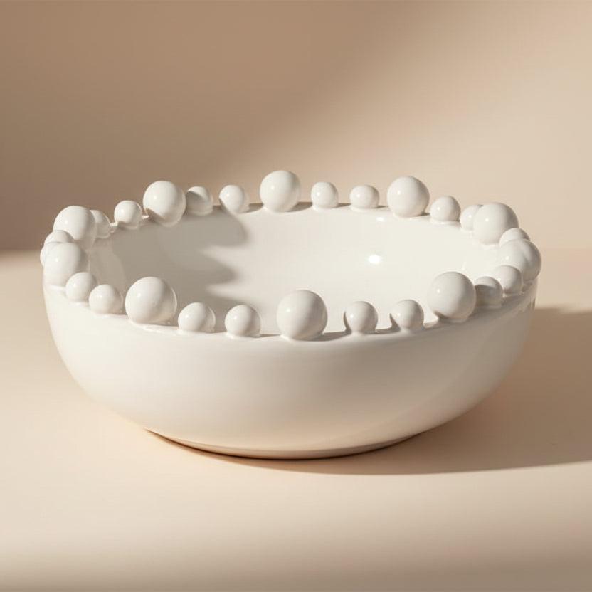 White ceramic bowl with bead-like protrusions on a white background