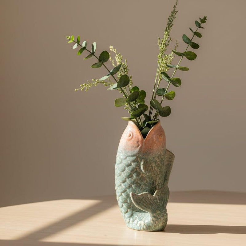 Decorative vase with fish design on a white background