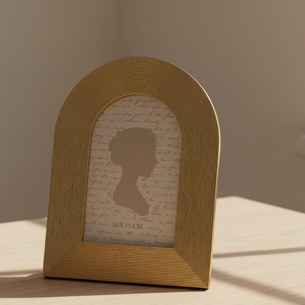Decorative photo frame with a textured gold border and silhouette design on a white background