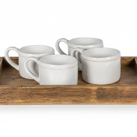 Set of four white mugs with brown rim on a white background