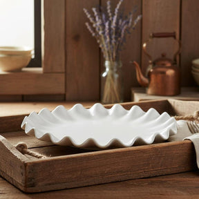 White ceramic dish with wavy edge on a white background