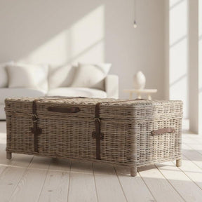 Wicker coffee table in a bright living room with white sofa and large windows.