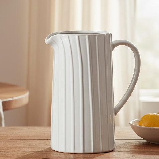 White ceramic pitcher with ribbed texture on a white background