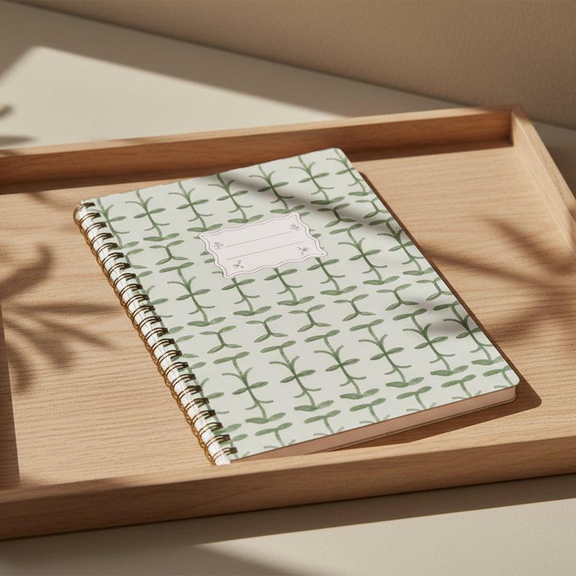 Notebook with green leaf pattern on a white background