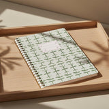 Notebook with green leaf pattern on a white background