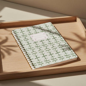 Notebook with green leaf pattern on a white background