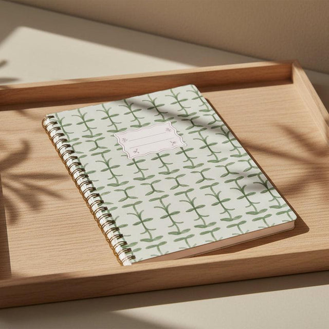 Notebook with green leaf pattern on a white background