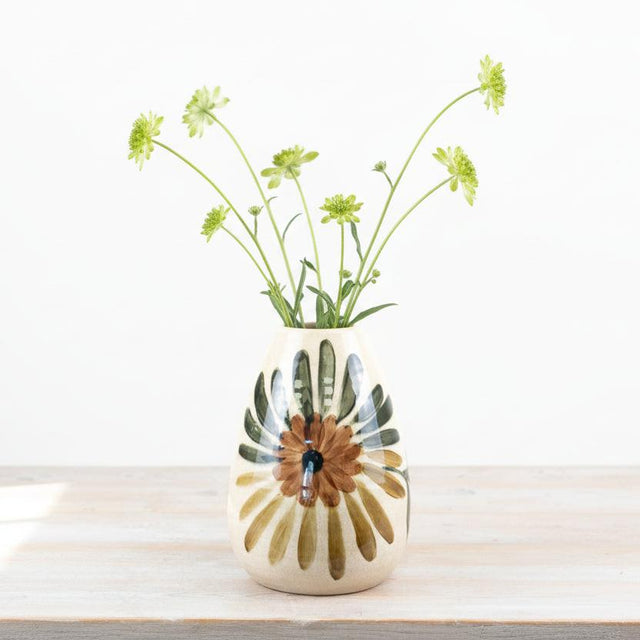 Ceramic vase with floral design on a wooden surface