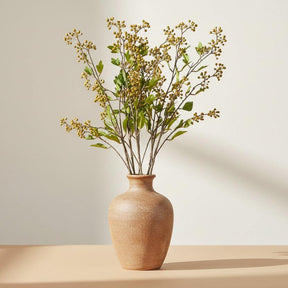 Artificial plant with green leaves and small yellow flowers on a white background