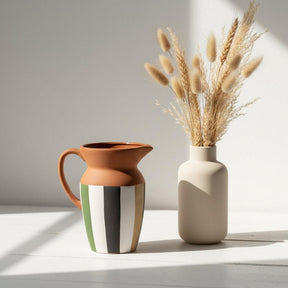 Ceramic pitcher with a striped design on a white background